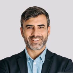 Front view of businessman smiling with arms crossed on white background